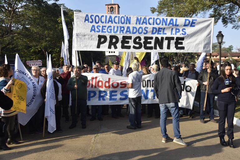 Manifestación de asegurados y jubilados del IPS frente a la casa del presidente electo, Santiago Peña. Cuestionan administración de Vicente Bataglia y critican el informe de Mario Abdo Benítez.