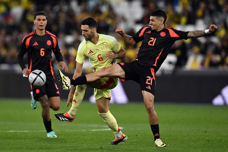 Colombia's defender #21 Daniel Munoz challenges Spain's midfielder #06 Mikel Merino during the international friendly football match between Spain and Colombia at The London Stadium in east London on March 22, 2024. (Photo by Ben Stansall / AFP)