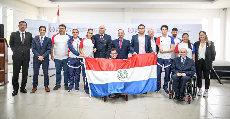 Iván Cáceres, el abanderado de Paraguay, posa con la tricolor junto a los paraatletas, entrenadores y dirigentes al finalizar el acto de abanderamiento.