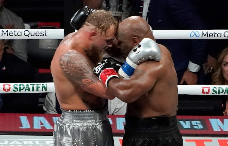 El youtuber Jake Paul  y el boxeador retirado Mike Tyson se abrazan en el ring del AT&T Stadium en Arlington, Texas.