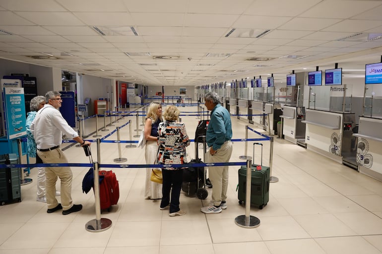 Unas personas se preparan para viajar este lunes en el Aeropuerto Internacional Silvio Pettirossi, en Luque.