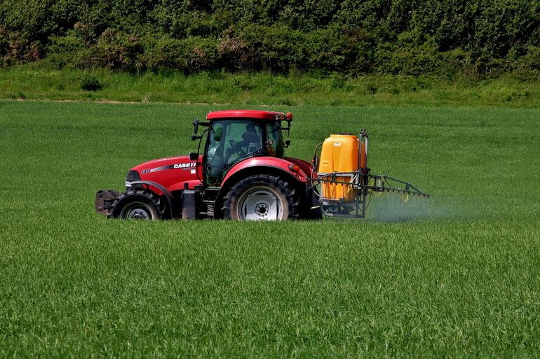 Un tractor rocía productos químicos al campo. Científicos piden buscar alternativas variadas para evitar afectacion a la biodiversidad.