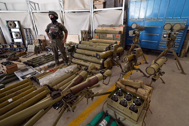 El mayor G, comandante del Instituto de Investigación de Armas de las Fuerzas de Defensa de Israel, posa junto a material militar requisado a Hezbolá en sus operaciones militares en el Líbano, este miércoles en la base militar de Julis (Israel). 