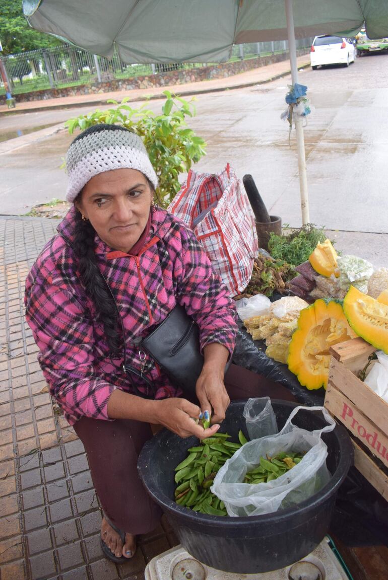 Doña Mariana desgrana poroto manteca en su puesto. Es reconocida por contar productos frescos en su puesto. 