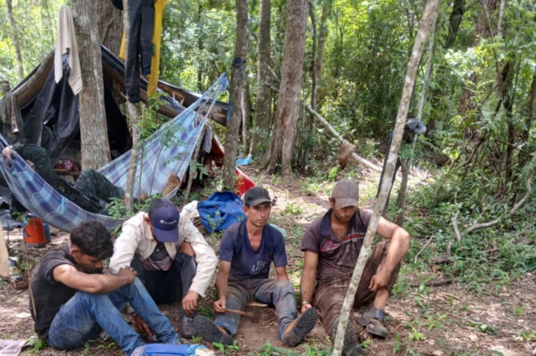 Cuatro de los sospechosos sentados en un sector del improvisado campamento, donde fueron sorprendidos. La Fiscalía pidió prisión para todos, por delito ambiental.