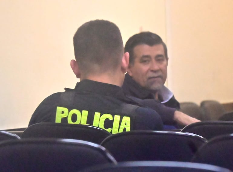 Francisco Pastor Alvarenga Núñez, excomandante de la Policía Nacional mirá al policía que lo custodiaba durante el juicio oral que terminó con su condena a 6 años de cárcel.