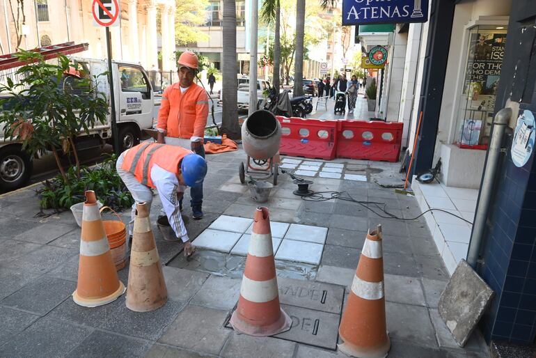 Obreros de las contratistas de ANDE empezaron ayer a arreglar las veredas de la calle Palma, con baldosas lisas y más claras que las que estaban anteriormente.