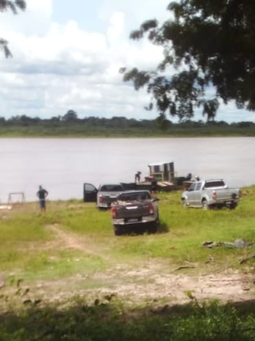 Vehículos a punto de ser transportados en la pequeña embarcación en Puerto Caballo hacia territorio Boliviano.