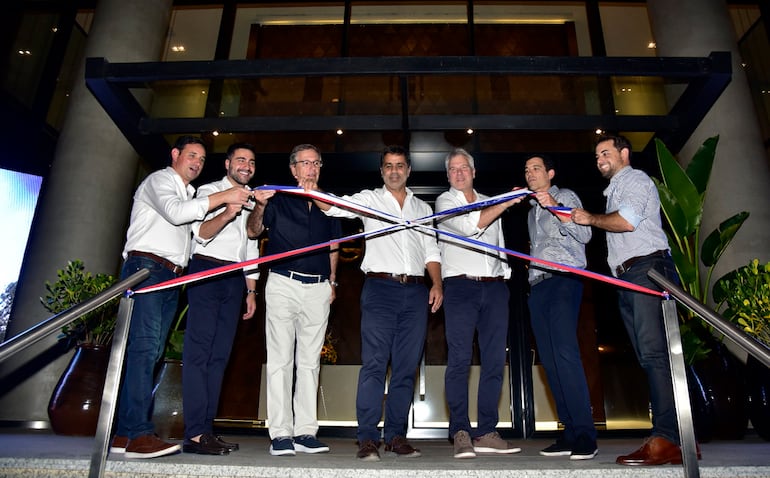 Momento en que los ejecutivos de la empresa desatan la cinta e inauguran la nueva moderna torre More del Sol, en Asunción.