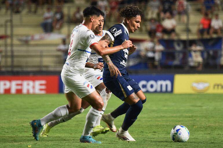 Paolo Guerrero (d), futbolista de Alianza Lima, disputa el balón en el partido contra Nacional por la Fase 1 de la Copa Libertadores 2025 en el estadio Arsenio Erico, en Asunción, Paraguay.