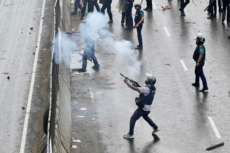 Policías de Bangladesh lanzando gas lacrimógeno.