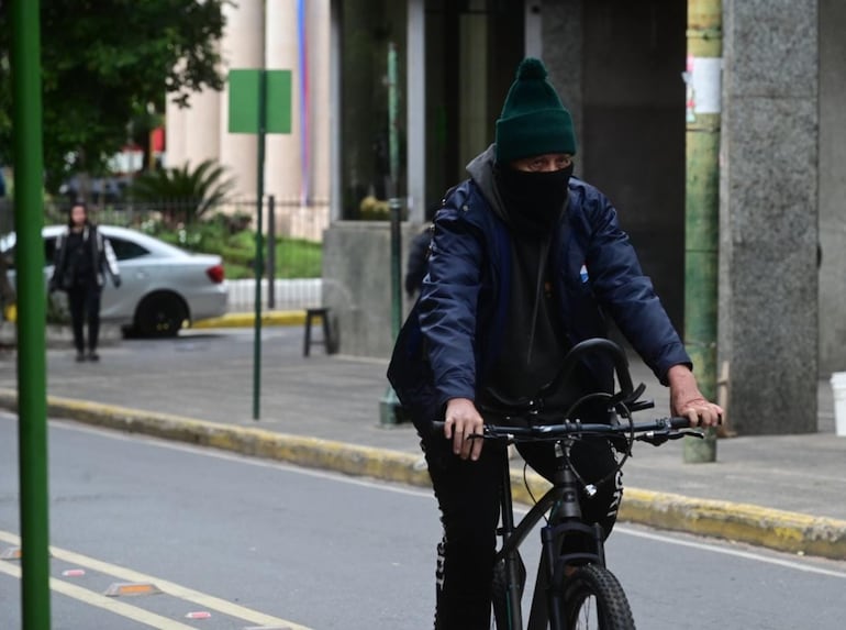 Un ciclista bien abrigado pedalea por la bicisenda de la calle Palma.