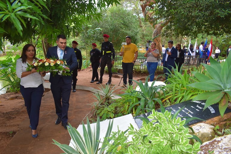 Ofrenda floral a cargo del Intendente Magín Benítez y la directora de cultura municipal Janice Ayala, en la tumba donde reposan los restos de Ortiz Guerrero a orillas del lago Ykuá Pytä.