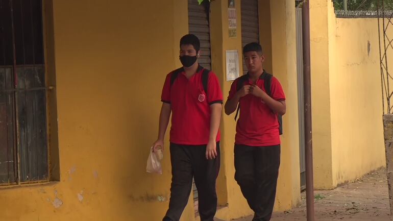 Una madre lleva a sus dos hijos estudiantes con tapabocas a la escuela, ante la baja calidad del aire por incendios forestales.