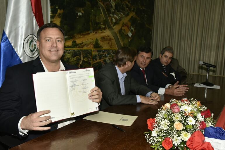 El entonces ministro del MOPC, Ramón Jiménez Gaona (procesado en el caso Metrobus), muestra orgulloso la firma del contrato de ampliación de la ruta 2 y  7 mediante la modalidad de APP, la única hasta ahora. (foto de archivo).