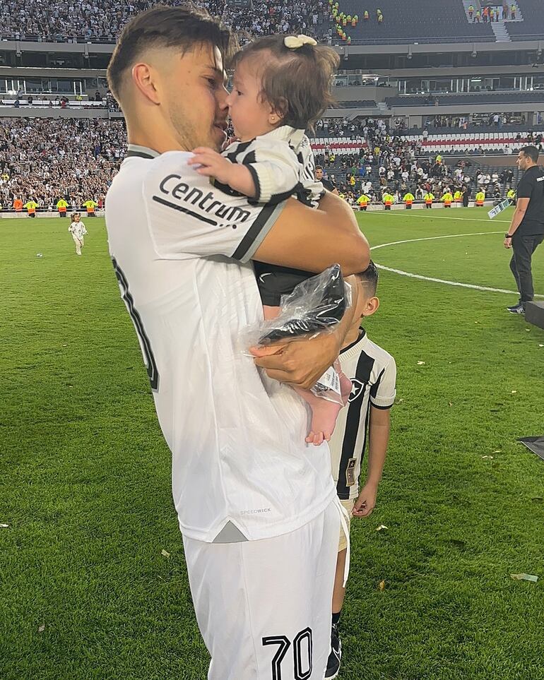 ¡Tierna postal! Óscar Romero con su hija Aitana Nicolle en el campo de juego del Monumental tras consagrarse campeón de la Copa Libertadores de América con Botafogo. (Instagram/Jani González)