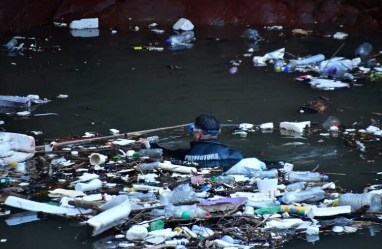 Buzos de la Armada Nacional realizan búsqueda en medio de la basura en el arroyo Lambaré.