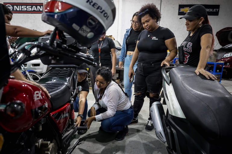 Mujeres en un taller durante un curso sobre mecánica básica para motorizadas, en Caracas (Venezuela).  