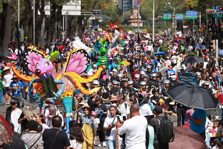 Personas asisten al desfile de alebrijes este sábado, en Ciudad de México (México). La capital mexicana inició las festividades del Día de Muertos .