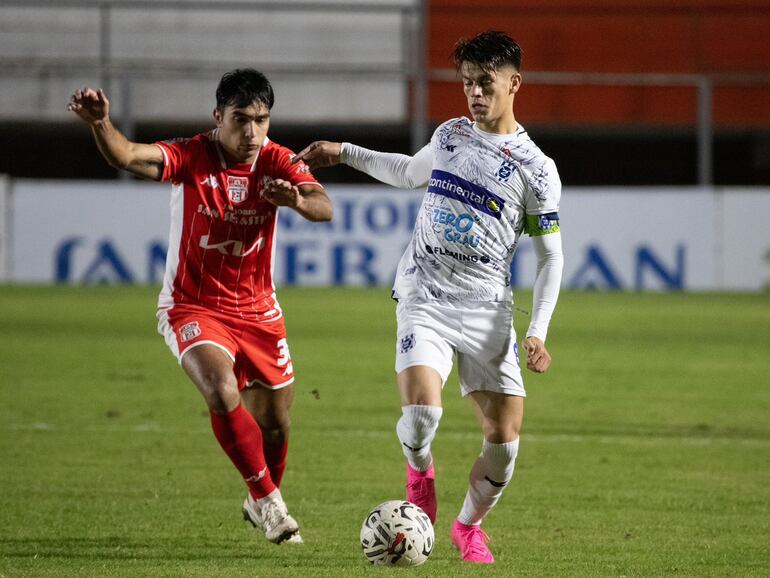 Pablo Ayala, jugador de General Caballero de Juan León Mallorquín, y Javier Domínguez, futbolista del 2 de Mayo de Pedro Juan Caballero, pelean por el balón en un partido de la fecha 20 del torneo Apertura 2024 del fútbol paraguayo en el estadio Ka'arendy, en  Juan León Mallorquín.