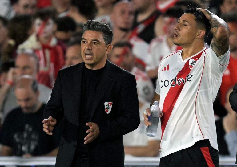 Adam Bareiro (d) recibiendo indicaciones del técnico Marcelo Gallardo antes de ingresar.