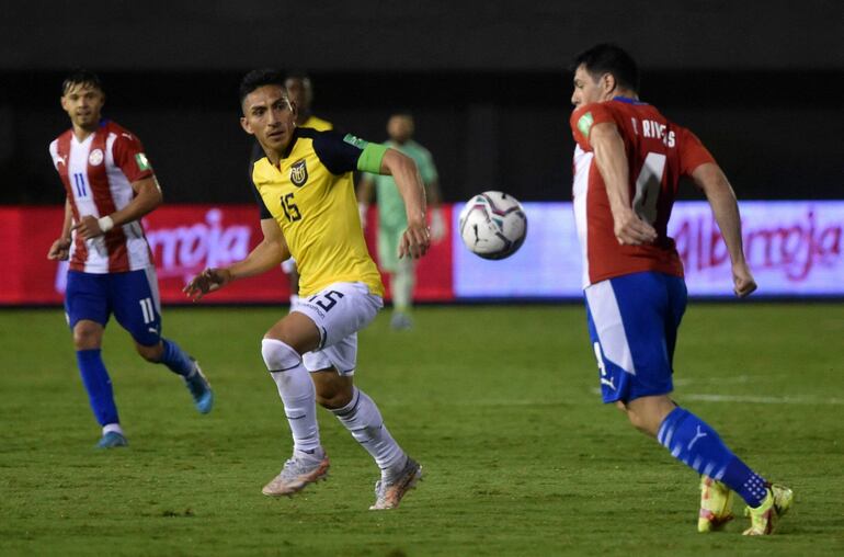 Blas Riveros (d), jugador de la selección paraguaya, domina el balón frente a Ángel Mena (i), futbolista de Ecuador, en un partido por las Eliminatorias Sudamericanas al Mundial Qatar 2022 en el estadio Antonio Aranda Encina, en Ciudad del Este, Paraguay.