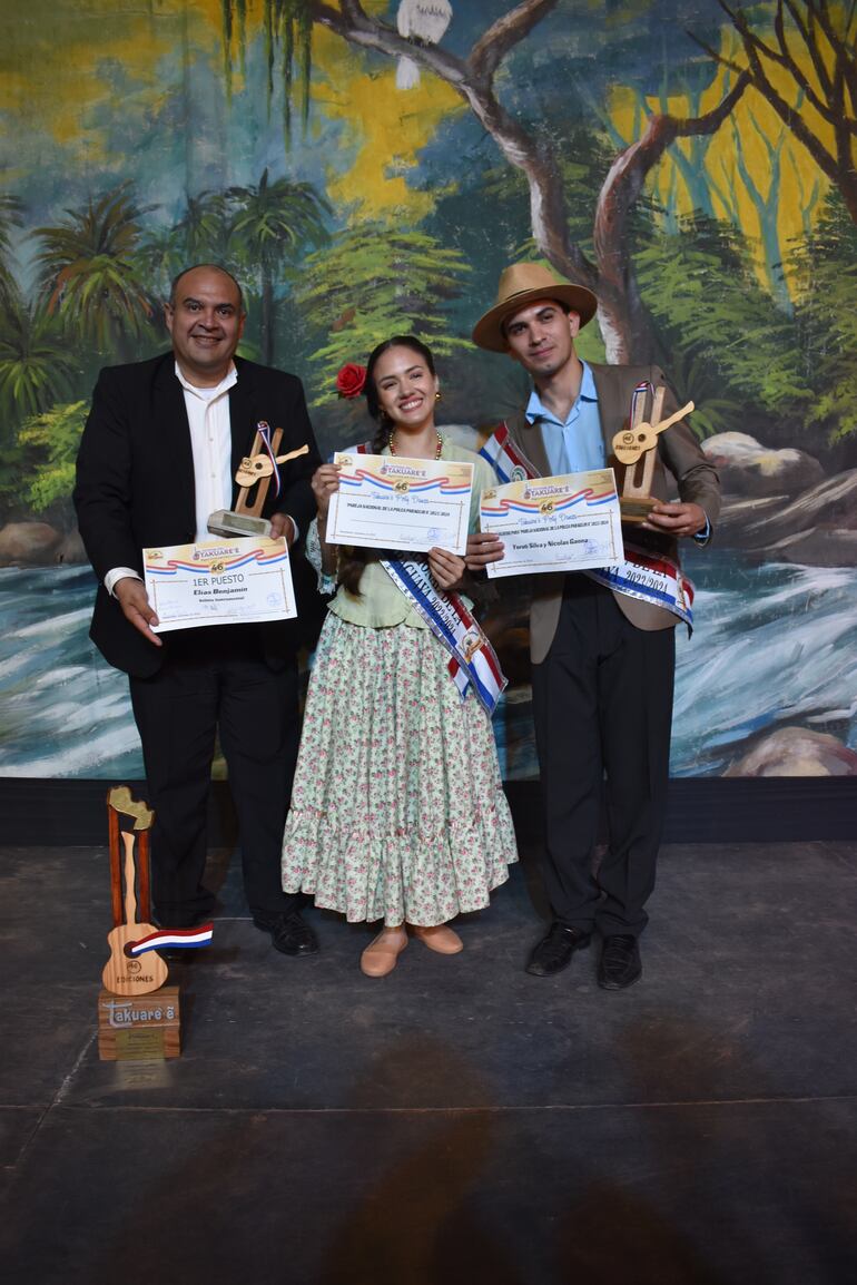 La pareja nacional de la polca paraguaya, Yeruti Silva y Nicolás Gaona, con Elías Benjamín, quien se llevó el trofeo de oro.