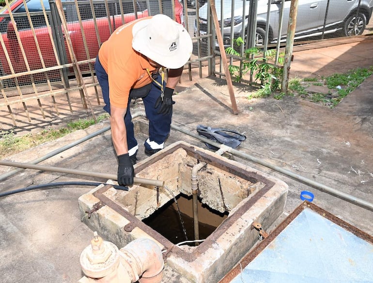 Un trabajador de MOPC verifica el poco caudal de agua que llega a un reservorio. 