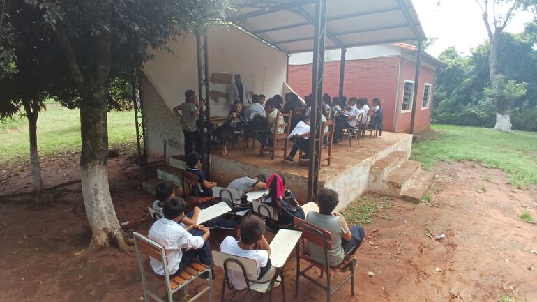 Alumnos reciben clases bajo arboles y en escenario y exigen la construcción de un aula.