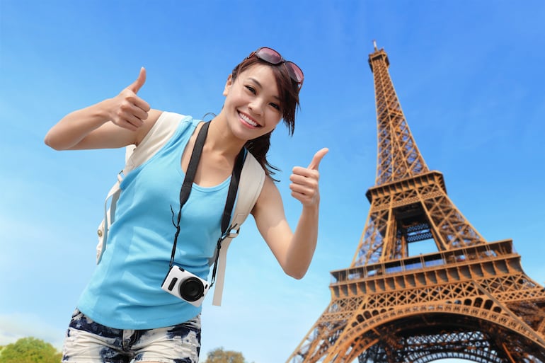 Turista posa con la Torre Eiffel de fondo, París, Francia.