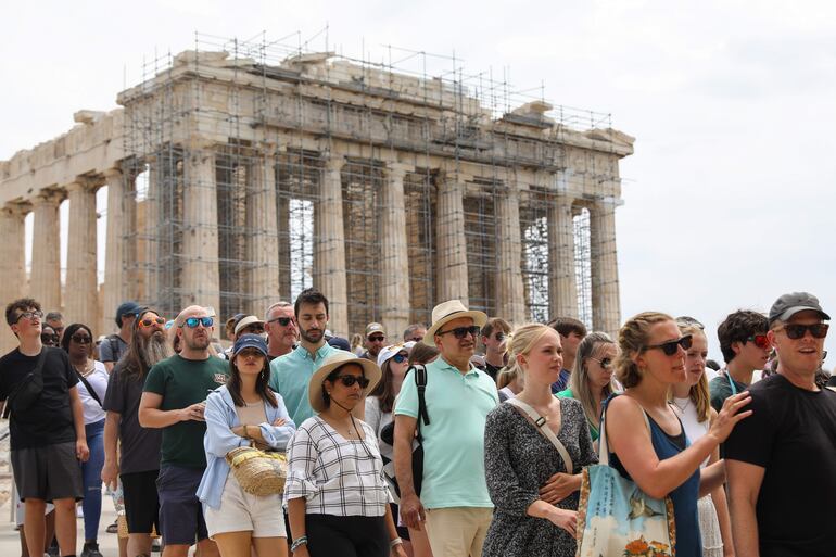 Turistas hacen cola para salir del yacimiento arqueológico de la Acrópolis, tras visitar el templo del Partenón en Atenas, Grecia.