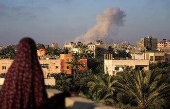 Una mujer observa el humo elevarse del sur de la Ciudad de Gaza luego de un bombardeo israelí, el martes.