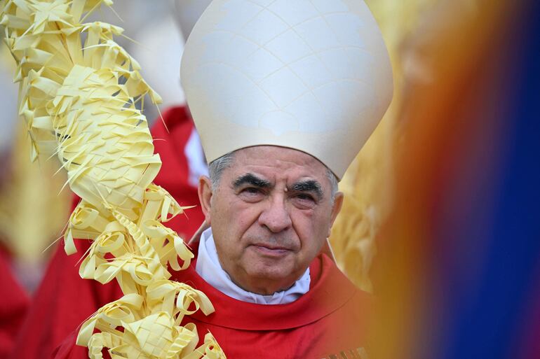 El cardenal italiano Giovanni Angelo Becciu participa en la procesión de la misa del Domingo de Ramos el 2 de abril de 2023 en la plaza de San Pedro en el Vaticano. El 16 de diciembre de 2023, un tribunal del Vaticano condenó al otrora poderoso cardenal italiano a cinco años y seis meses de cárcel por delitos financieros al final de un juicio histórico. Angelo Becciu, de 75 años, ex asesor del Papa Francisco y que alguna vez fue considerado un contendiente papal, había negado rotundamente cargos que incluían malversación de fondos y abuso de poder.