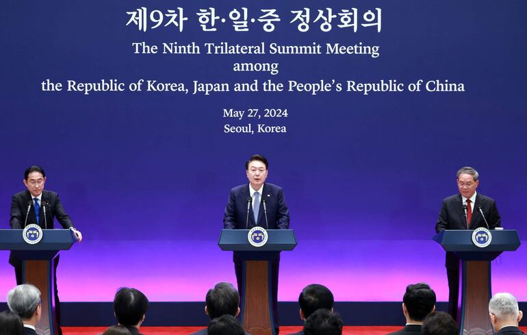 El presidente surcoreano Yoon Suk Yeol (C) habla durante la cumbre en Seúl junto al primer ministro de Japón, Fumio Kishida (i) y el primer ministro de China, Li Qiang (d).