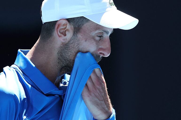 El serbio Novak Djokovic se seca la cara entre juegos durante su partido de semifinales individuales masculino contra el alemán Alexander Zverev en el día trece del torneo de tenis Abierto de Australia en Melbourne.