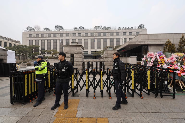 Agentes de policía hacen guardia mientras el tribunal celebrará la primera audiencia formal el mismo día del juicio político al presidente Yoon Suk Yeol por su efímera imposición de la ley marcial, con Yoon ausente de los procedimientos por motivos de seguridad, en el Tribunal Constitucional en Seúl, Corea del Sur.