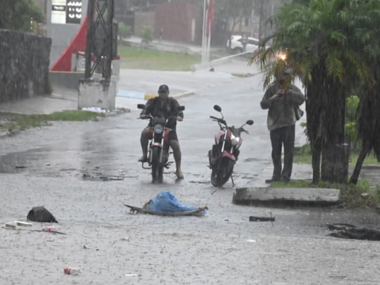 Motociclistas no pueden cruzar la vía ante la lluvia.