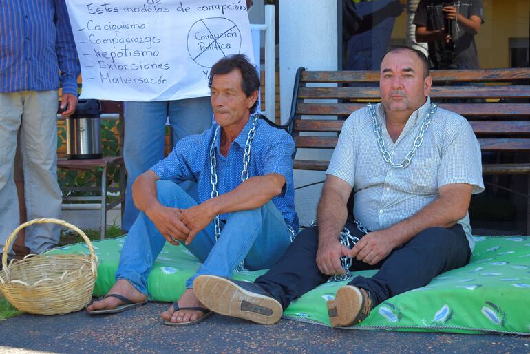 El concejal municipal Hugo Vázquez (derecha), encadenado junto al señor Arcadio Sánchez, frente a la Municipalidad de Mauricio J. Troche.