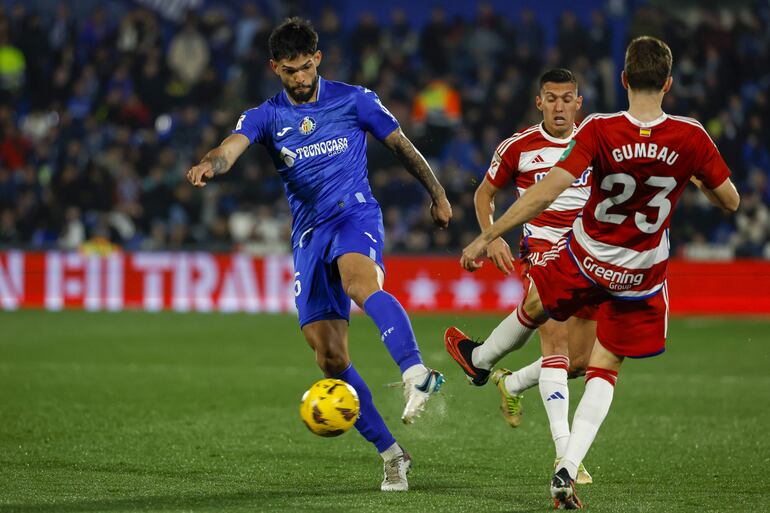 MADRID, 29/01/2024.- El defensa paraguayo del Getafe, Omar Alderete (i), disputa el balón ante Gerard Gumbau (d), centrocampista del Granada, durante el encuentro de la jornada 22 de LaLiga que disputan Getafe CF y Granada CF, este lunes en el Estadio Coliseum en Getafe. EFE/ JuanJo Martín
