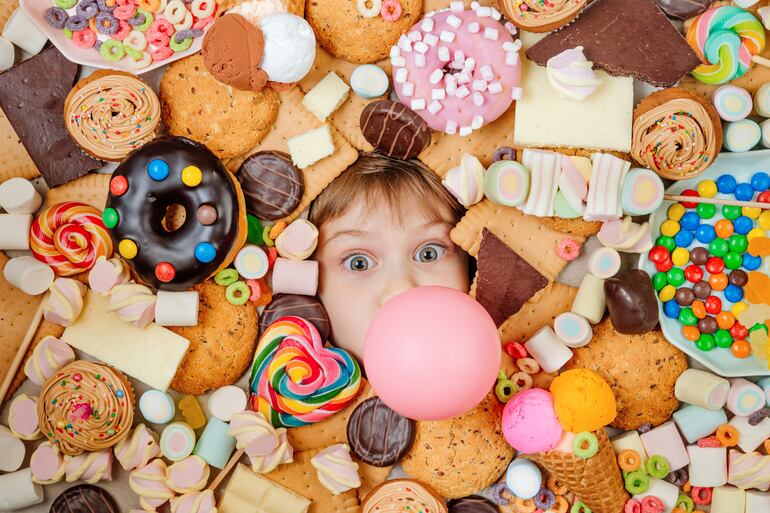 Una niña entre golosinas y dulces.