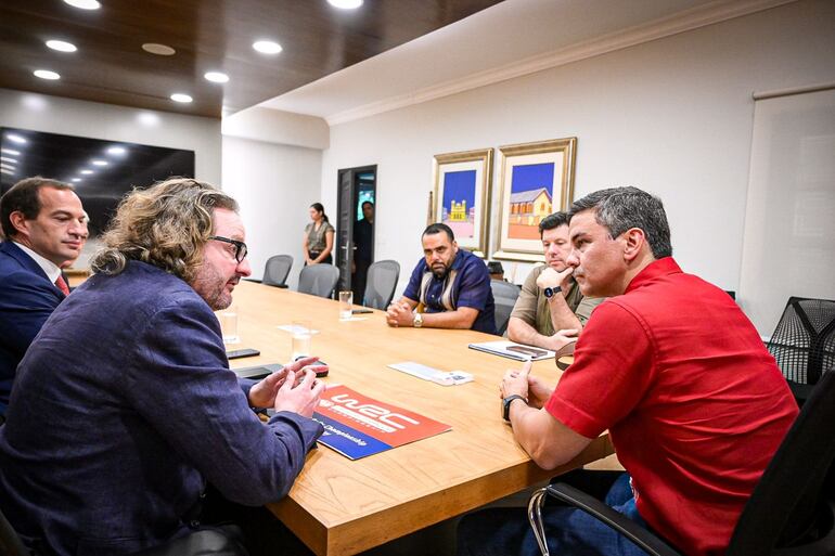 El presidente Santiago Peña (d) en conversación con Simon Larkin en Mburuvichá Roga, ayer.