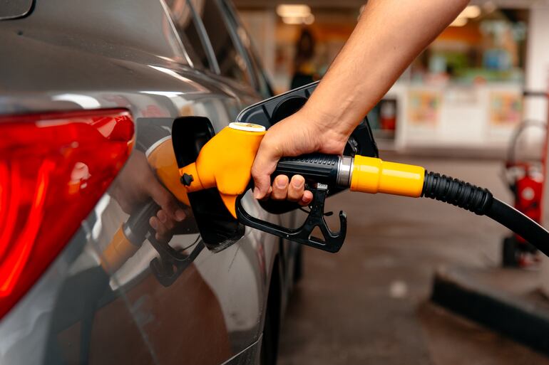 Una persona carga combustible en una estación de servicio.