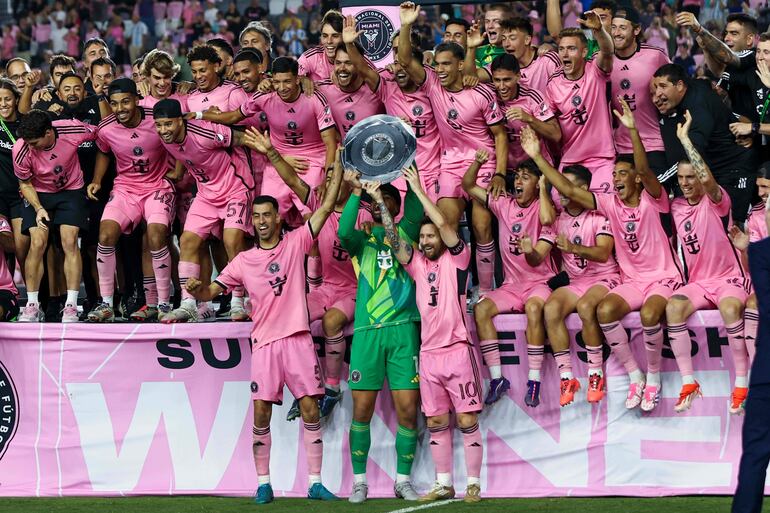 TOPSHOT - Inter Miami's Spanish midfielder #05 Sergio Busquets, Uruguayan forward #09 Luis Suarez, US goalkeeper #01 Drake Callender and Argentine forward #10 Lionel Messi hold the Supporters' Shield after the Major League Soccer (MLS) football match against New England Revolution at Chase Stadium in Fort Lauderdale, Florida, October 19, 20 (Photo by Chris Arjoon / AFP)