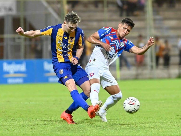 El argentino Paul Charpentier, jugador de Sportivo Luqueño, y el colombiano Rafael Carrascal, futbolista de Cerro Porteño, pelean por el balón en el partido por la séptima jornada del torneo Clausura 2023 del fútbol paraguayo en el estadio Villa Alegre, en Encarnación.