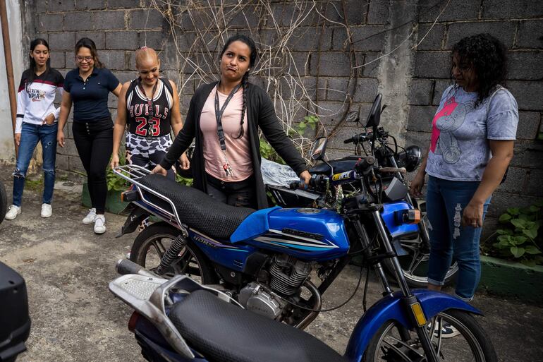 Jackeline González (frente) preparando su moto en un curso sobre mecánica para motorizadas en Petare, la barriada más grande de Caracas (Venezuela). Las alumnas del taller y las organizadoras reconocen que cada día hay más mujeres motoristas, por lo que -coinciden- es más necesario que nunca tener nociones de mecánica en un mundo en el que ellas llevan décadas luchando por el derecho a su autodeterminación y demostrando su manera de hacer tareas que antes les habían sido negadas.