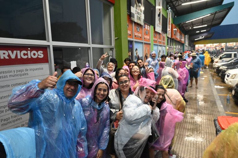 Fans de Karol G refugiándose de la lluvia