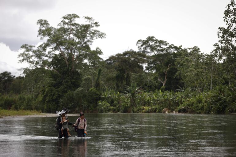 Luis, un migrante venezolano de 25 años, carga a su hijo Matías Infante de 1 año junto a su esposa Sharon Morales de 19 años a través del río Tuquesa, luego de atravesar la selva del Darién, este jueves en el Darien (Panamá). El director de la Aecid, Antón Leis, visitó esta semana el poblado al que llegan a diario cientos de migrantes tras atravesar durante días la peligrosa selva del Darién, la frontera natural entre Colombia y Panamá, donde recordó que nadie "recorre miles de kilómetros por capricho y mucho menos para cometer delitos", sino porque huyen de guerras, hambre o miseria, las causas profundas de la crisis migratoria global.