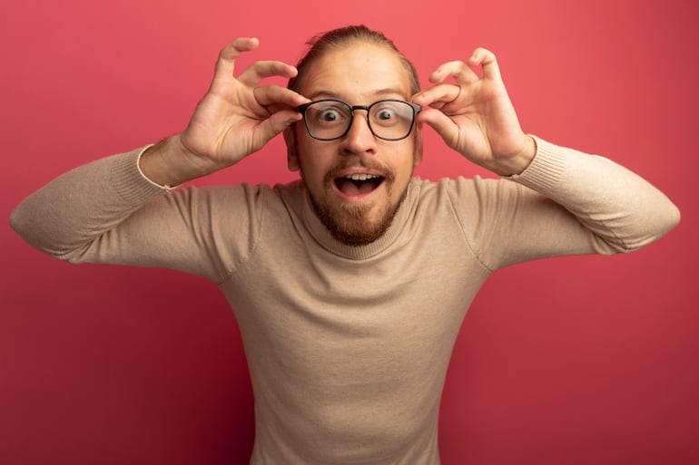 Hombre sonriente acomodándose los anteojos.