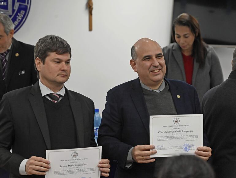 Los doctores César Ruffinelli Buongermini y Ricardo Sasiaín Sosa exhiben los certificados del TEI que los ratifica como representantes electos de las Universidades Privadas ante el Consejo de la Magistratura (CM)