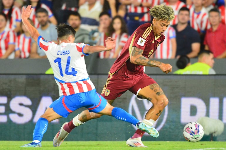 Andrés Cubas (i), jugador de la selección de Paraguay, pelea por el balón en el partido frente a Venezuela por la fecha 10 de las Eliminatorias Sudamericanas 2026 en el estadio Defensores del Chaco, en Asunción.